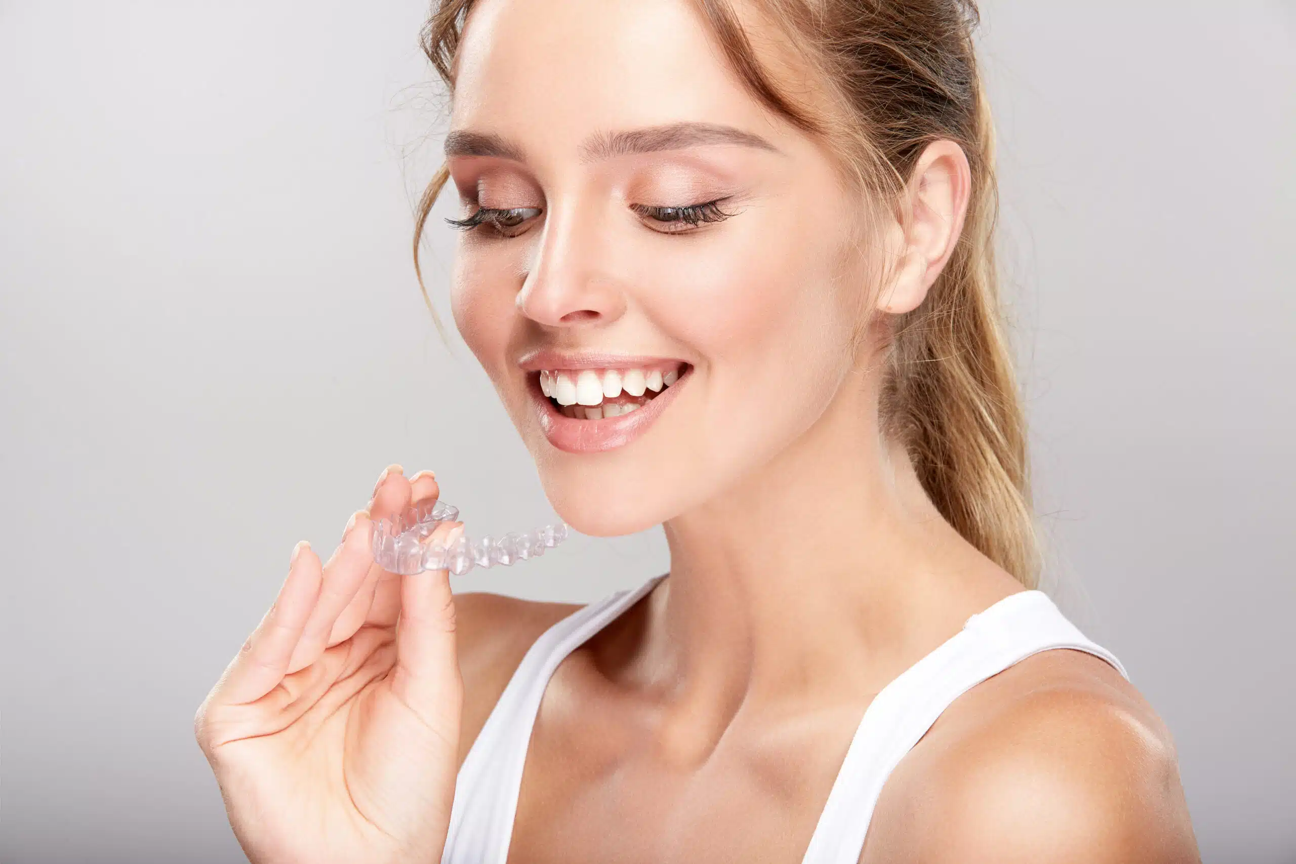 Woman holding a clear dental aligner