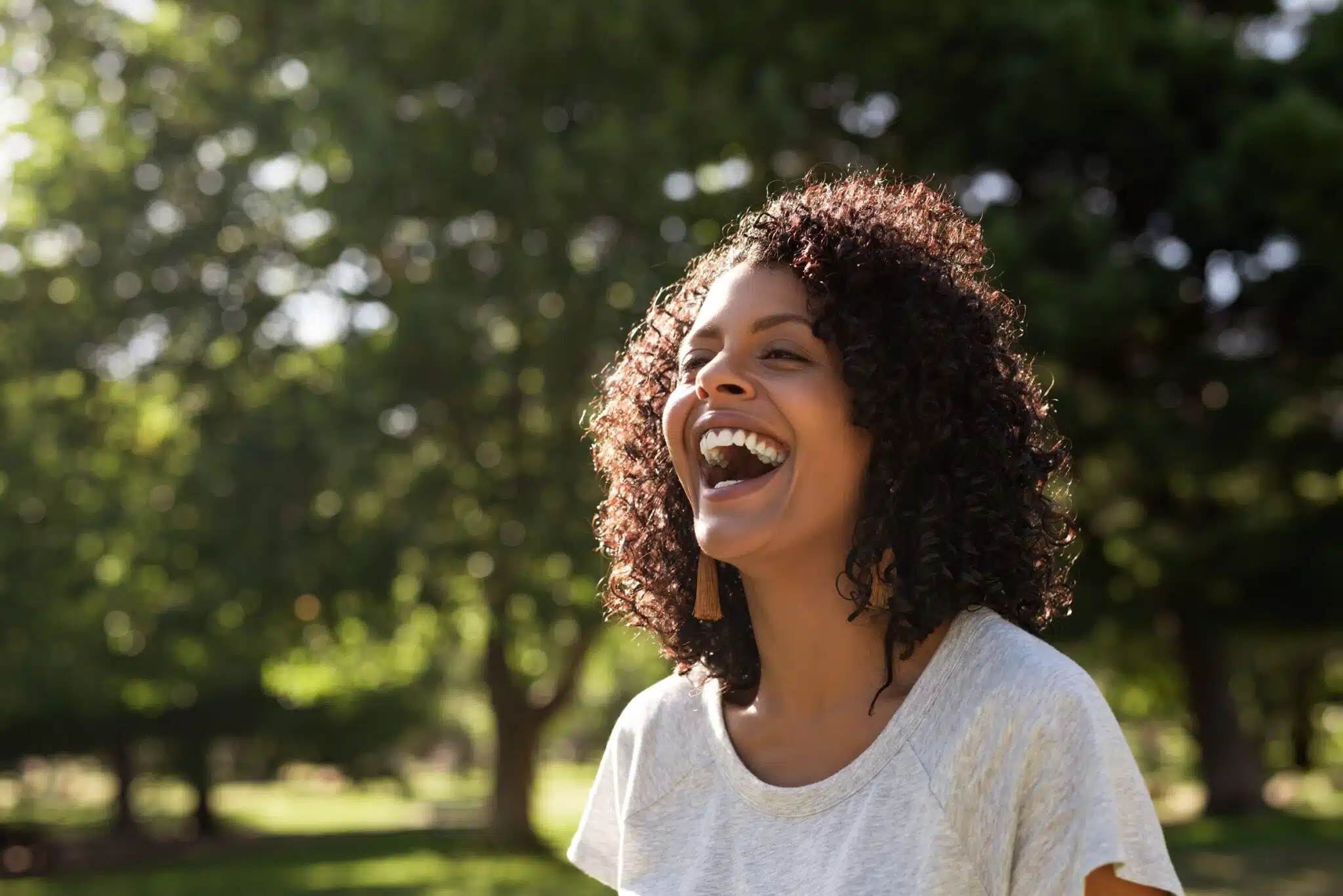 Woman smiling outdoors during personalized dental care
