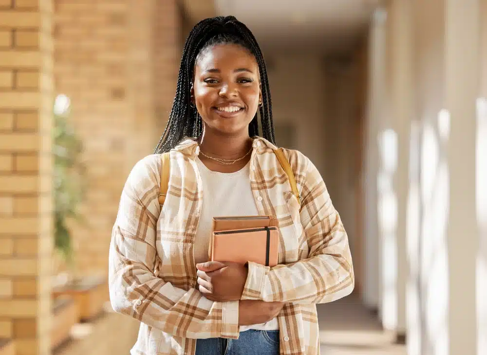 Woman smiling while holding some books or file