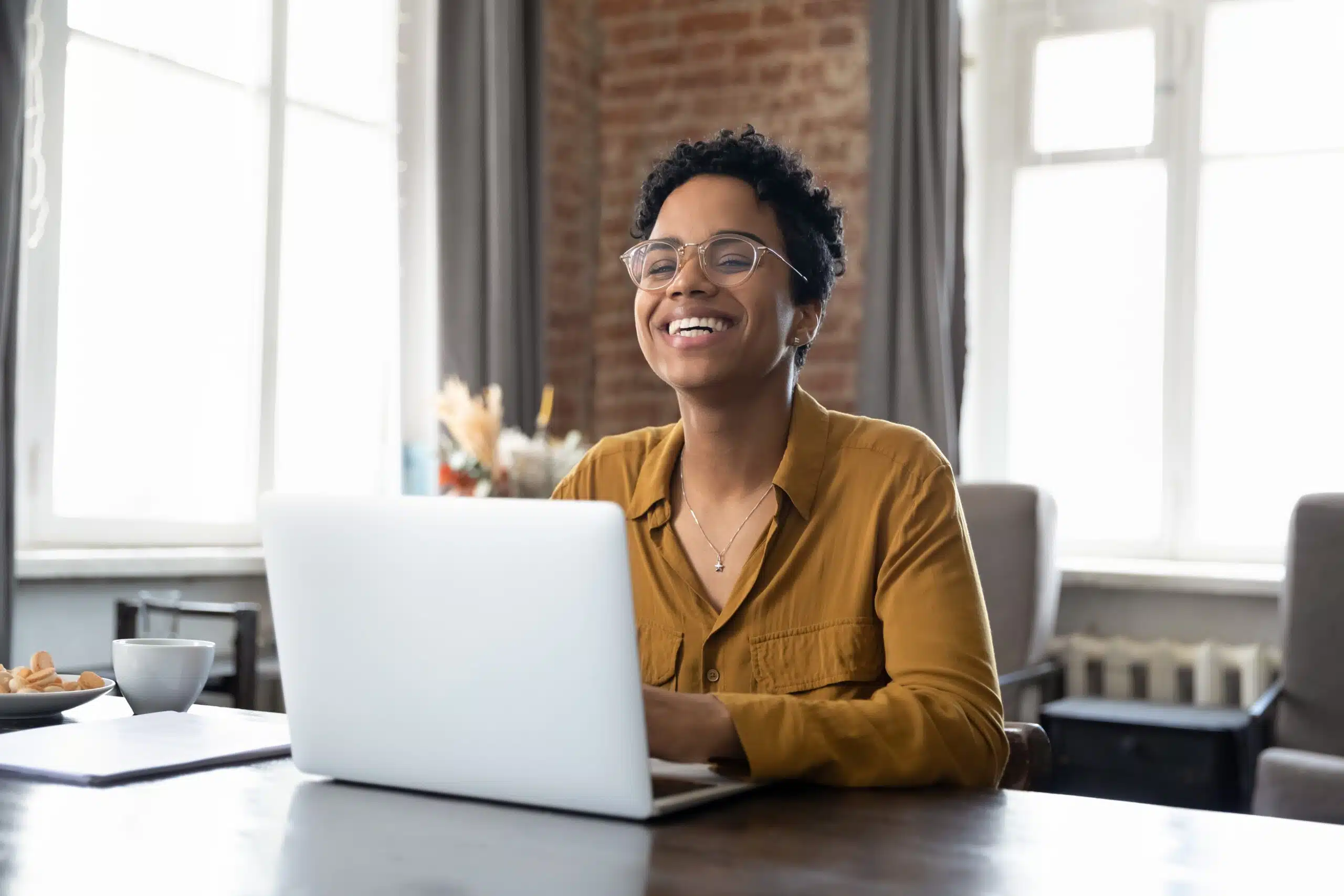 Woman smiling while working on a laptop