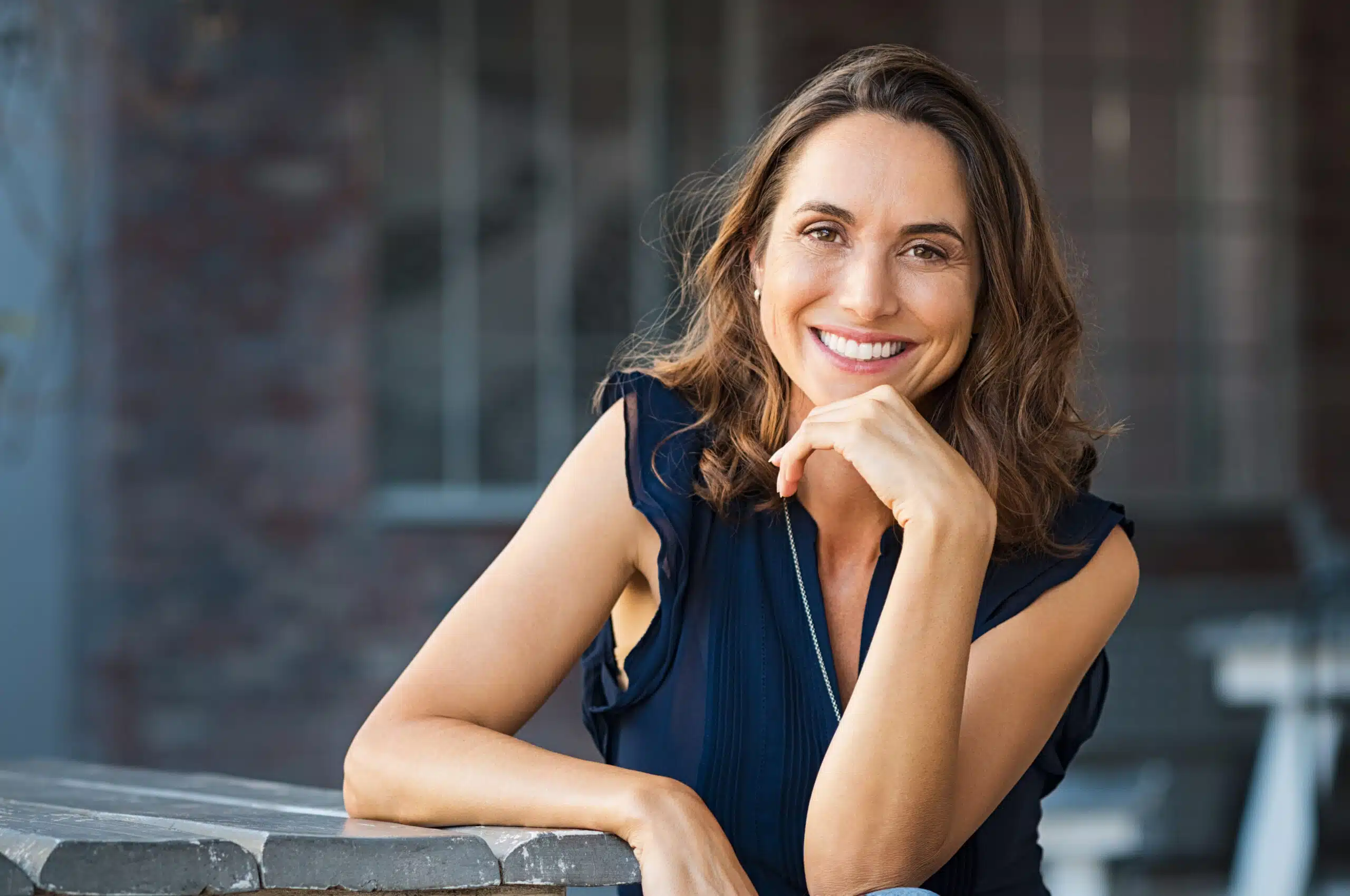 Woman smiling while resting her chin on her hand
