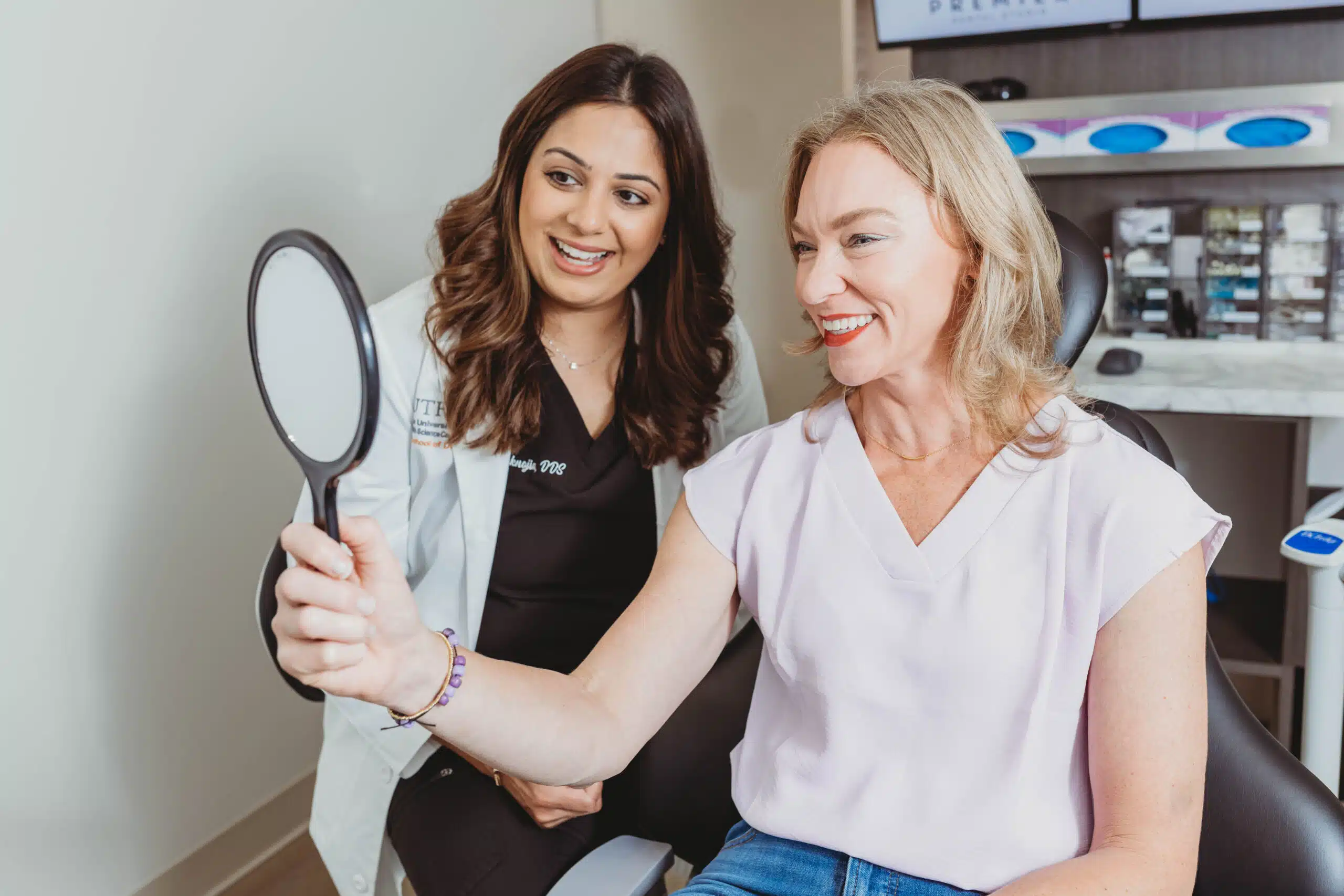 Dentist explaining porcelain veneers to an older woman during a dental consultation
