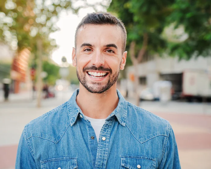 Man smiling after considering cosmetic dental treatments for smile improvement